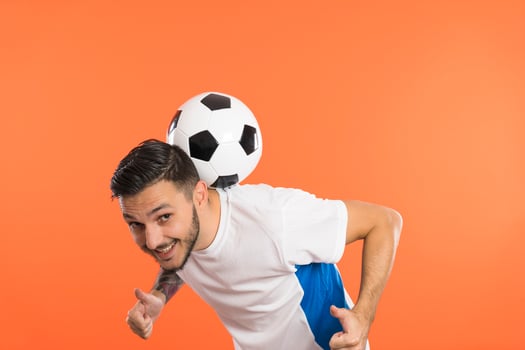 Young Man football soccer player balancing soccer ball on the back of neck and giving thumbs up photo