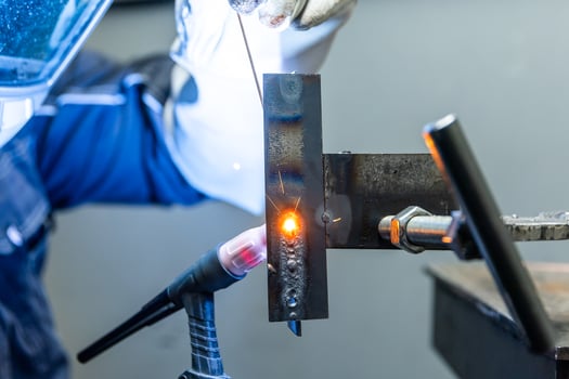Welder worker welding a pieces of metal in the industrial factory, heavy weld industry concept photo