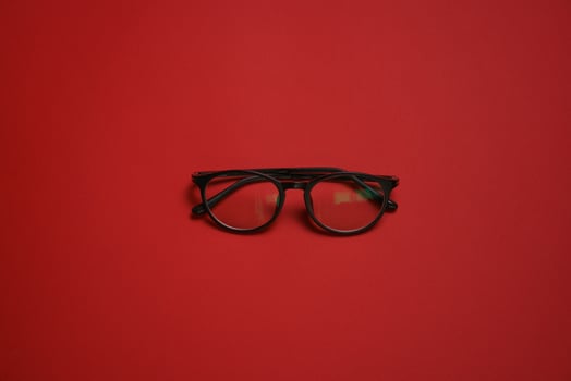 Plastic card style fashion glasses style isolated on dark red background photo