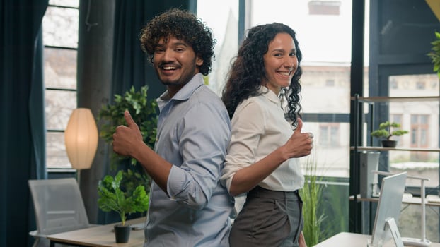 Excited multiracial colleagues business partners Arabian Indian man businessman and Hispanic woman businesswoman co-workers looking at camera happy smile showing thumb up gesture good idea in office photo