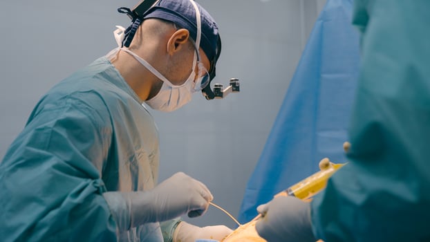 Doctor man physician surgeon perform plastic surgery liposuction surgical laparoscopic abdominal operation with medical instruments syringe in nurse hands anesthesia patient belly medical health care photo