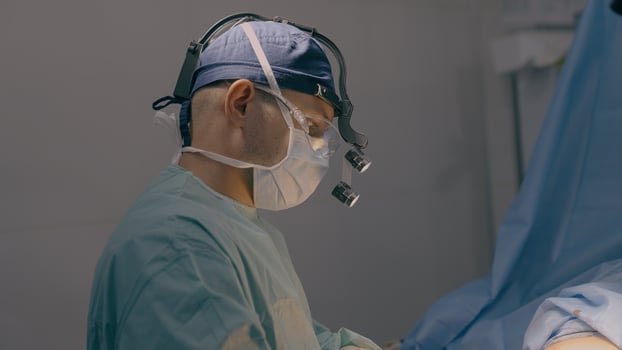 Male doctor man surgeon physician neurosurgeon practitioner medic in medical mask perform surgical operation in operating room disease surgery with microscope in hospital clinic health care medicine photo