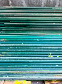 Turquoise pipes stacked on the ground photo