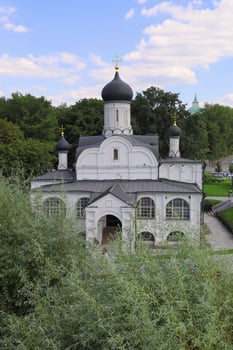 The summer view of the beautiful Russian Orthodox Church with domes and crosses surrounded by trees. photo