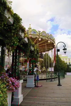Carousel Attraction Ride With Wooden Horses in summer park with flowers in Moscow in Russia. photo