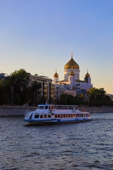 The ship sails along the Moskva River and orthodox church in Russia in Moscow. photo