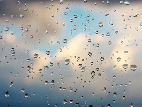 Water drops of rain on blue glass background. Rain drops on window photo