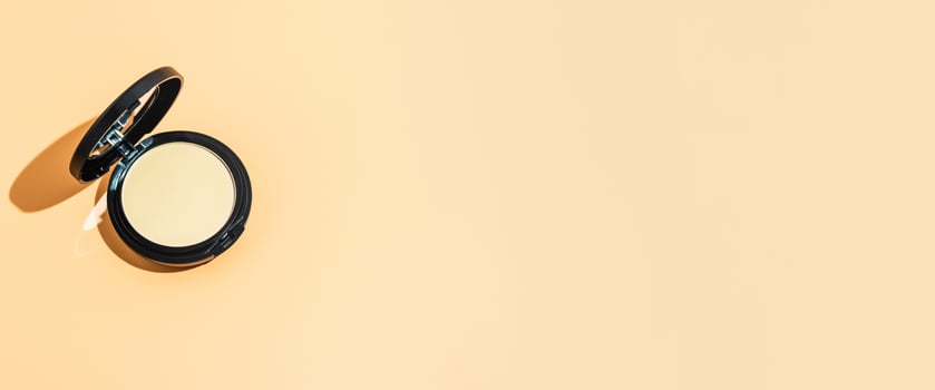 Compact powder on yellow background, copy space photo