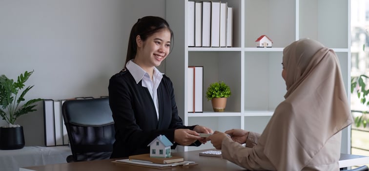 A real estate agent offers a house to a female Muslim client. The concept of buying and selling houses and real estate. photo