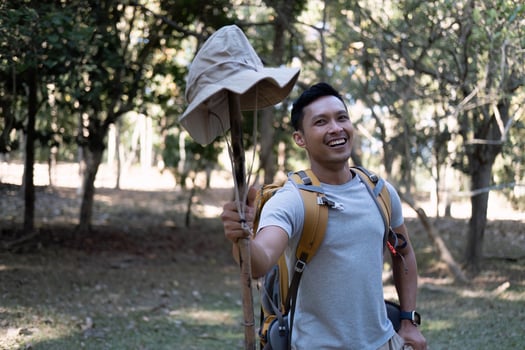 Portrait of a happy smiling Asian tourist, 30-35 years old, backpacking in a national park. asian male tourist enjoying his hiking trip Nature activities, holidays, outdoor hobbies. photo