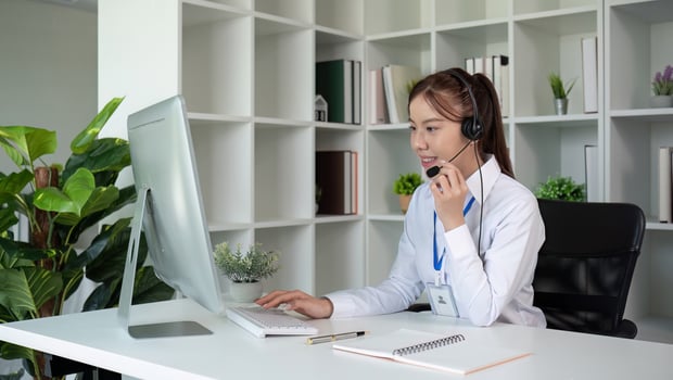 Call center agents wear headphones to talk to customers. Provide consultation via online channels on laptops photo