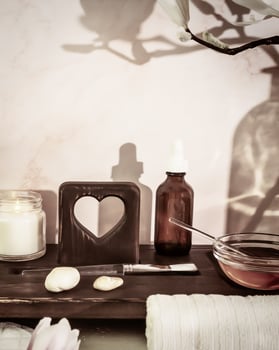 Cosmetology workplace with spa accessories, serum, candle and white towel on a wooden board photo