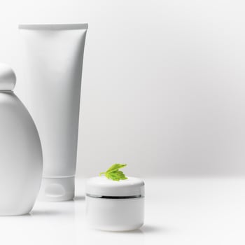 White plastic cosmetic bottle, tube and jar with lilac flowers photo