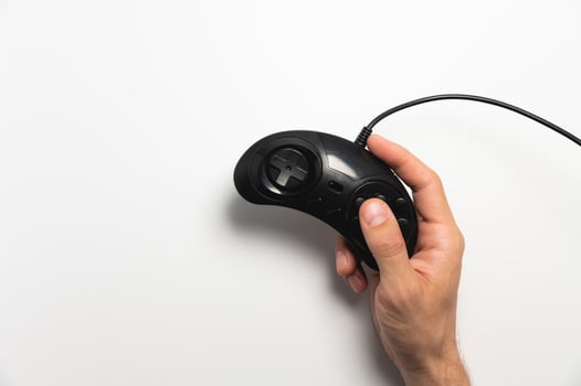 Black retro joystick on a white background in a man's hand. View from above photo