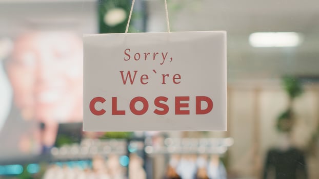 Extreme close up shot of message on fashion boutique door announcing customers that shop is closed. Sorry we are closed sign in empty eco friendly second hand clothing outlet photo