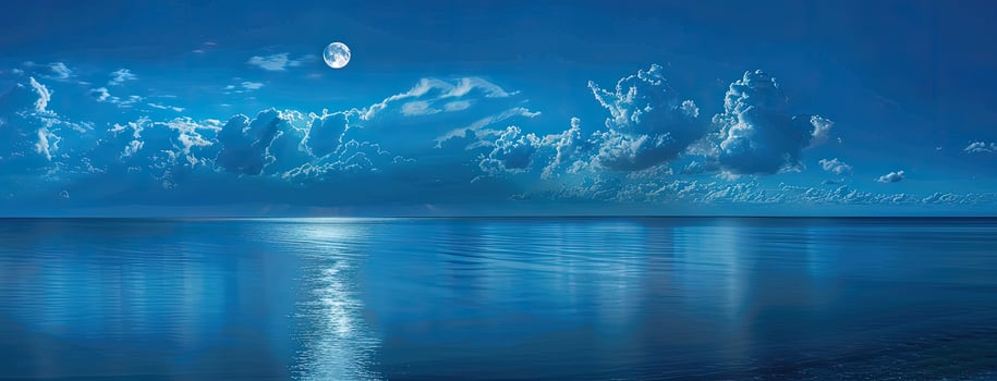 A blue sky with clouds and a moon over the ocean photo