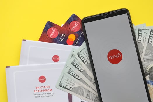 TERNOPIL, UKRAINE - JULY 7, 2023 Mobile banking application of Pumb Online in Ukraine. Background from banknotes and money photo