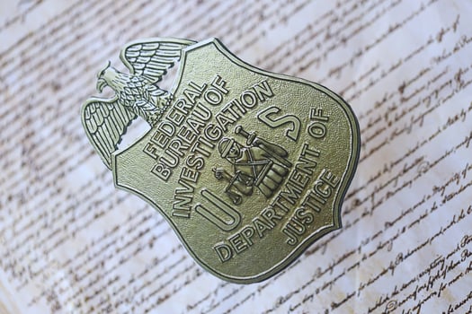 KYIV, UKRAINE - MARCH 9, 2024 US FBI Federal Bureau of Investigation badge on United States Constitution photo