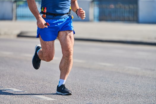 Athletic man jogging in sportswear on city road photo