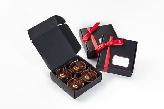 Exquisite coffee cup shaped chocolates in black gift boxes photo