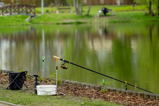 fishing gear on the shore of a city pond, fishing rod and chair, hobby photo