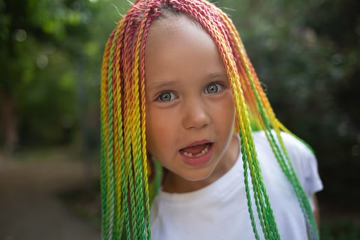 portrait of a little beautiful girl with multi-colored african braids photo