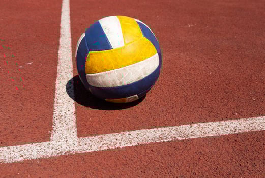 volleyball. blue with yellow color ball on the playground. volleyball cover, red. ball game photo