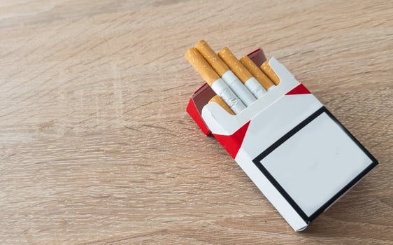 Pack of cigarettes on wooden textured table photo