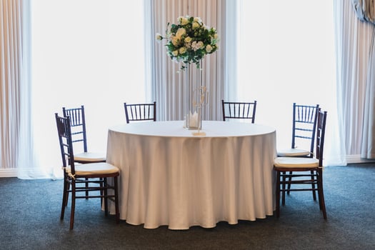 Decorated interior for festive event. Fancy table set for dinner with flower composition in restaurant, luxury interior background. Wedding elegant banquet decoration arranged by catering service photo