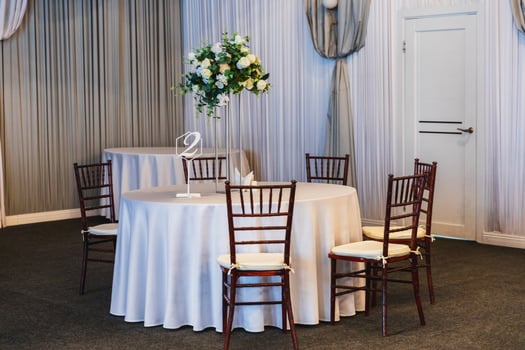 Decorated interior for festive event. Fancy table set for dinner with flower composition in restaurant, luxury interior background. Wedding elegant banquet decoration arranged by catering service photo