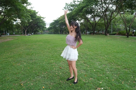 A joyful youn g woman dances in harmony indoors, with large windows and a scenic view enhancing the harmony and peace. photo