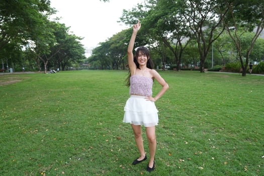 A joyful young woman dances in harmony indoors, with a dec orative brick wall and lush plants enhancing the harmony and peace. photo
