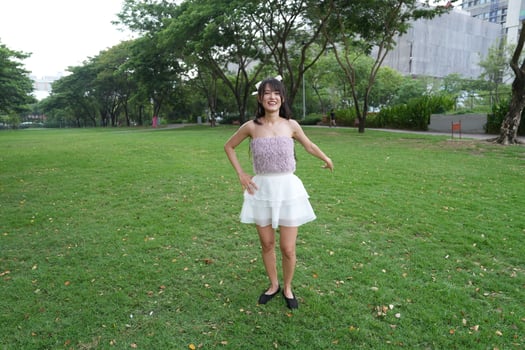In a calm i ndoor area, a woman dances freely near large windows and a scenic view, radiating freedom and energy. photo