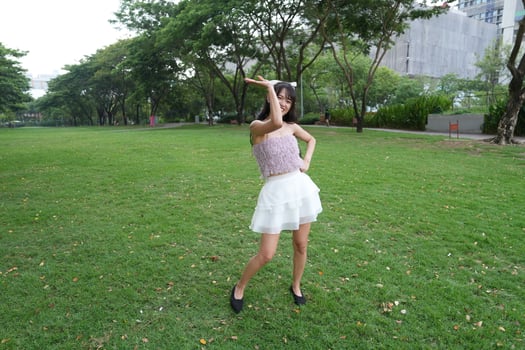 A woman dances happily indoo rs, set against large windows and lush plants, symbolizing harmony and peace. photo