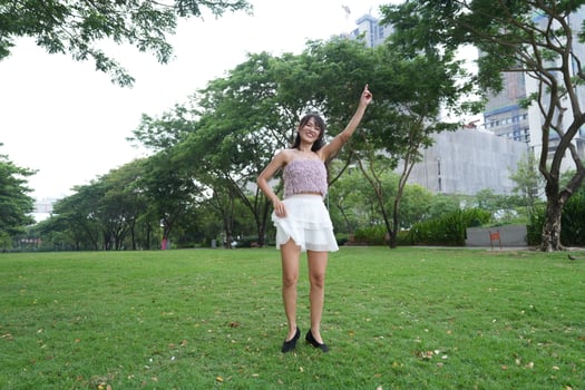 A young woman dances j oyfully in a serene indoor space, framed by large windows and a scenic view, embodying freedom and energy. photo