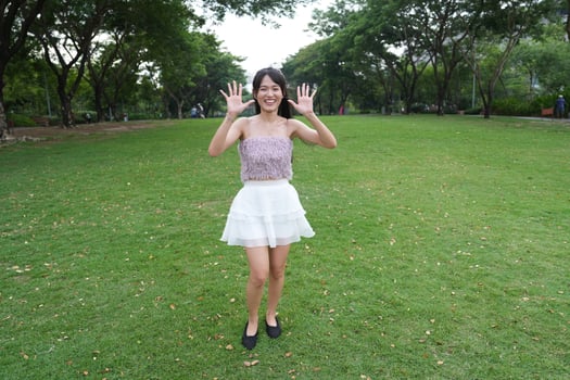 A joyf ul young woman dances in harmony indoors, with a decorative brick wall and lush plants enhancing the harmony and peace. photo