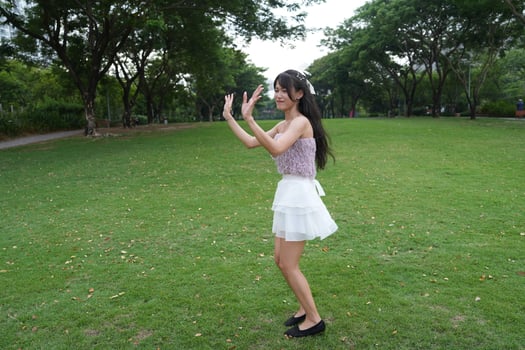 a lively indoor space, a woman dances happily near large windows, with a serene view bringing harmony and energy. photo