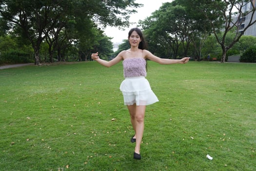 A joyful young woman dances in harmony indoors, with large win dows and a scenic view enhancing the harmony and peace. photo