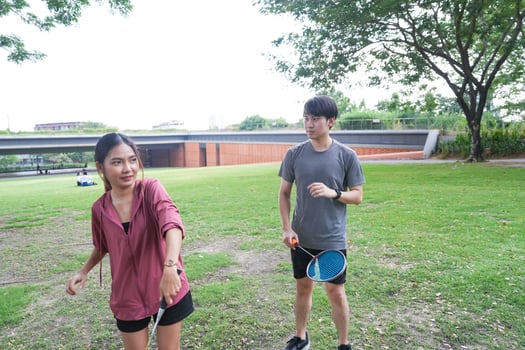 Young people play badminton and repair diligently in the park area. photo