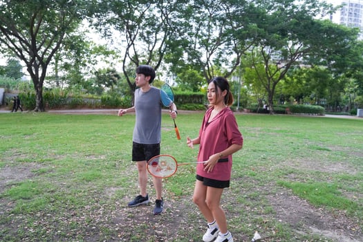Young people play badminton and repair diligently in the park area. photo