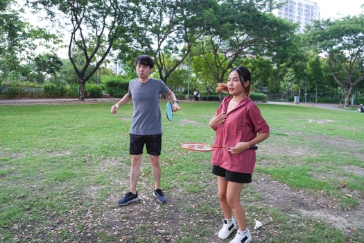 Young people play badminton and repair diligently in the park area. photo