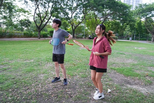 Young people play badminton and repair diligently in the park area. photo