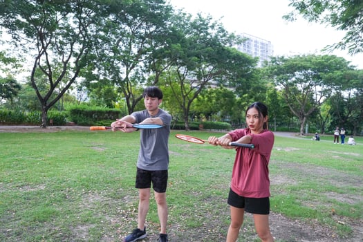 Young people play badminton and repair diligently in the park area. photo