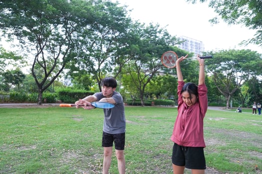 Young people play badminton and repair diligently in the park area. photo