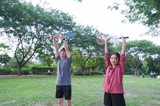 Young people play badminton and repair diligently in the park area. photo