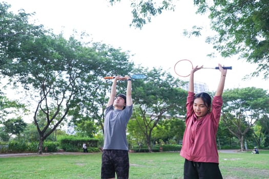 Young people play badminton and repair diligently in the park area. photo