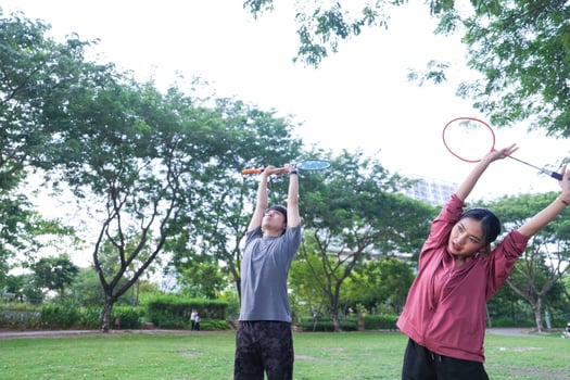 Young people play badminton and repair diligently in the park area. photo