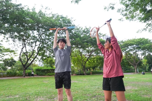 Young people play badminton and repair diligently in the park area. photo