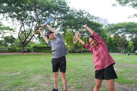 Young people play badminton and repair diligently in the park area. photo