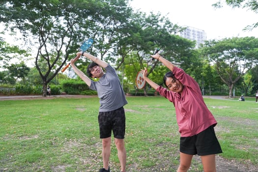 Young people play badminton and repair diligently in the park area. photo